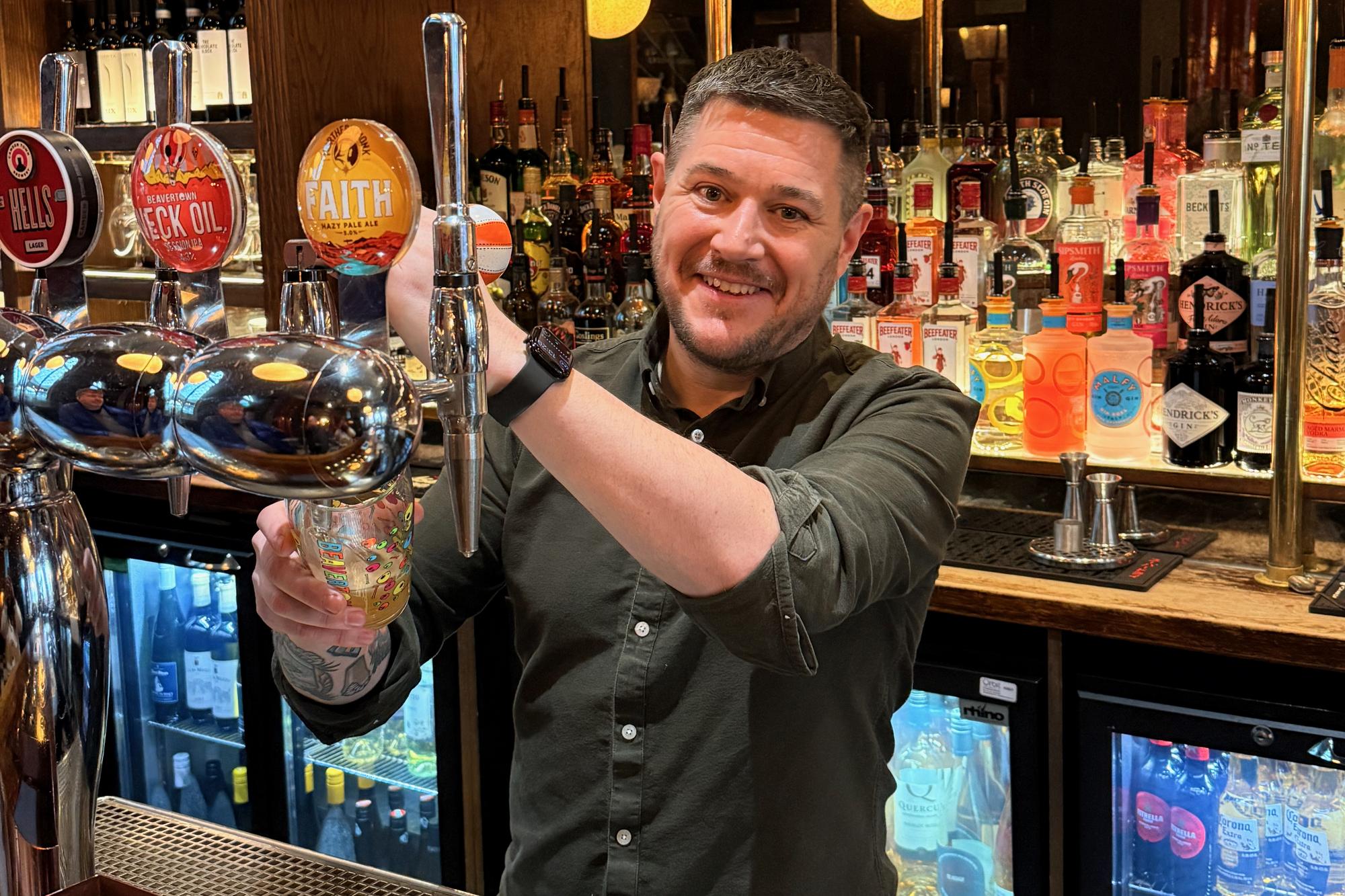 James Wilson behind the bar pulling a pint